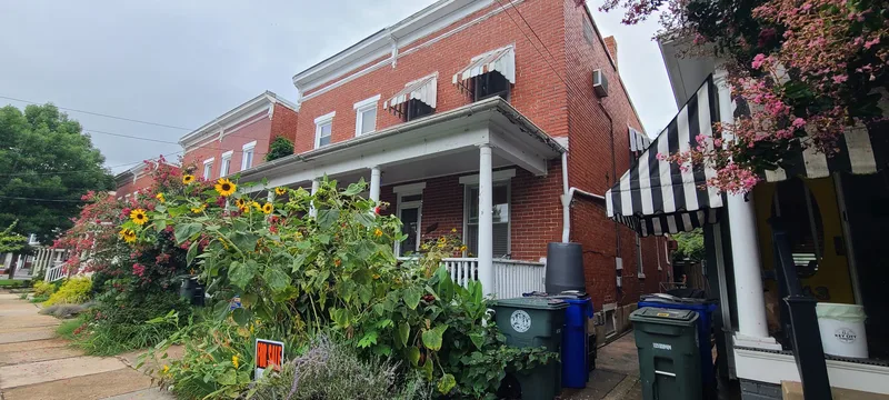 Front of house, flower garden, front porch. Brick with white trim. 