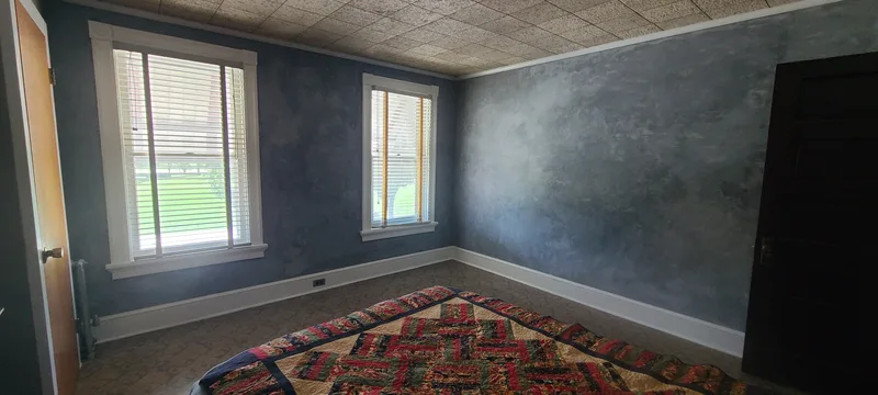 Front bedroom. Grey walls, white trim, two windows