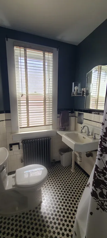 Upstairs bathroom, vintage white sink, white subway tile with black trim, grey walls, white shower curtain, black and white hex tile floor